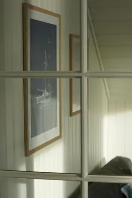 a shelf with a picture of a boat on a wall at Waterfront Rorbu - By the Beach in Bud