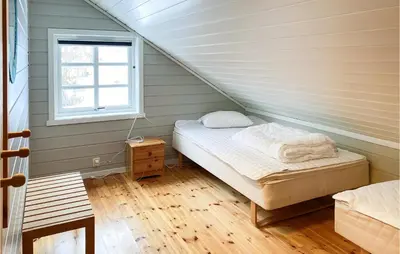 a room with a bed in a attic with a window at 4 Bedroom Nice Home In Midsund in Midsund