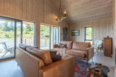 a living room with a couch and a table at Unique new cabin by Hafjell & Skei with stunning view in Tretten
