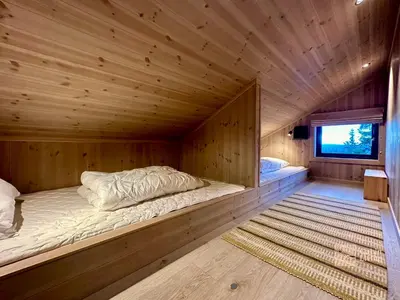 a large wooden room with a bed in a cabin at Unique new cabin by Hafjell & Skei with stunning view in Tretten
