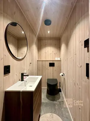a bathroom with a sink and a toilet and a mirror at Unique new cabin by Hafjell & Skei with stunning view in Tretten