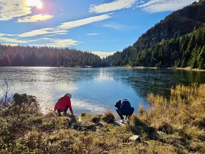 two people standing on the shore of a lake at Unique new cabin by Hafjell & Skei with stunning view in Tretten