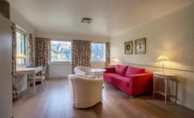 a living room with a red couch and a table at Stalheim Hotel in Stalheim