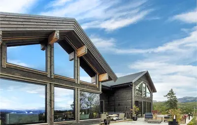 a house with large windows and a view of the mountains at Awesome Home In Norheimsund With Sauna in Norheimsund