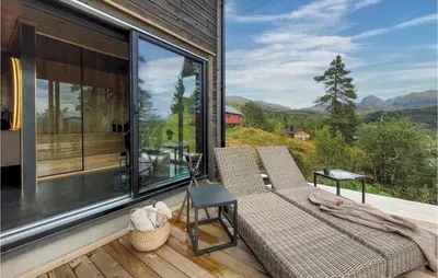 a screened in porch with two chairs and a table at Awesome Home In Norheimsund With Sauna in Norheimsund