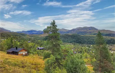 a house on a hill with mountains in the background at Awesome Home In Norheimsund With Sauna in Norheimsund