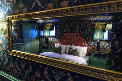 a mirror reflection of a bed in a bedroom at Charmante Skostredet Hôtel in Bergen