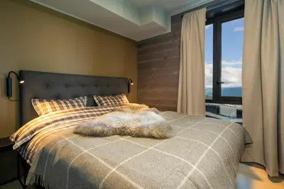a furry animal laying on a bed in a bedroom at Riddergaardens eleganse in Beitostøl