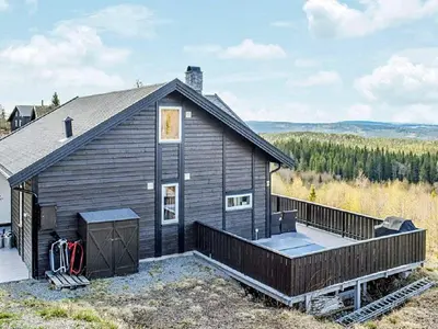a black house with a large deck in front of it at 4 star holiday home in Fall-By Traum in Raufoss