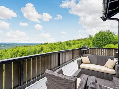 a deck with chairs and a couch on a balcony at 4 star holiday home in Fall-By Traum in Raufoss