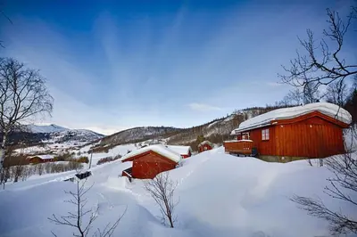 a couple of red buildings in the snow at Kvetos naturopplevelser in Beitostøl