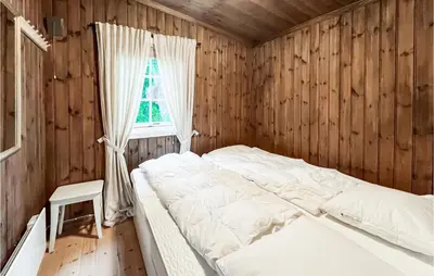a bedroom with a bed in a wooden wall at Beautiful Home In Sjusjøen With Kitchen in Sjusjøen