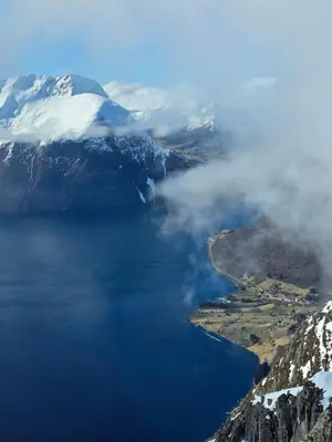 an aerial view of a lake with snow covered mountains at Apartment, Rekkedal Gjestegard - Sæbø in Ørsta