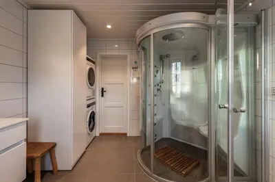a walk in shower in a bathroom with a washer and dryer at Sunny and beautiful cabin in Geilo in Geilo