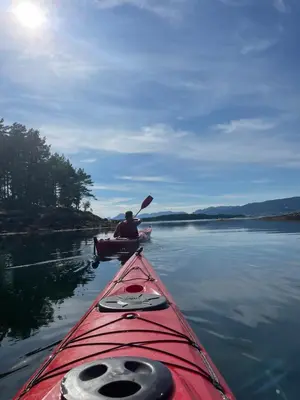 a man in a kayak on a lake with a paddle at Draget gård, historisk våningshus ved sjøen, rett utenfor Molde in Molde