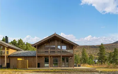 a large wooden house with large glass windows at 4 Bedroom Nice Home In Bjorli in Bjorli