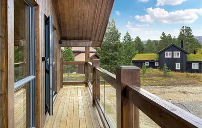 a wooden balcony with a view of a house at 4 Bedroom Nice Home In Bjorli in Bjorli