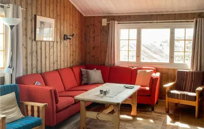 a living room with a red couch and a table at 3 Bedroom Lovely Home In Hemsedal in Hemsedal