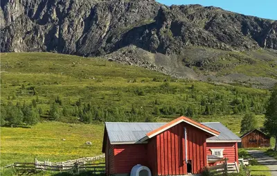 a red barn in a field next to a mountain at 3 Bedroom Lovely Home In Hemsedal in Hemsedal