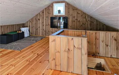 a room with wood paneled walls and a tv in a attic at Awesome Home In Hjartdal With Kitchen in Hjartdal