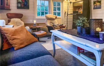 a living room with a couch and a table at Nice Home In Follafoss With Lake View in Sela