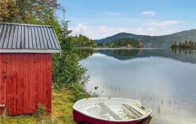 a boat sitting on the side of a body of water at Nice Home In Follafoss With Lake View in Sela