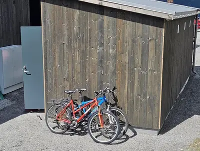 two bikes parked next to a wooden fence at Fin leilighet med flott utsikt til Gaustatoppen in Rjukan