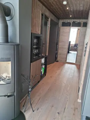 a living room with a fireplace and a wooden floor at Fin leilighet med flott utsikt til Gaustatoppen in Rjukan