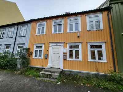 an orange house with white windows and a door at Mars Modern and Cozy Apartment in the centre, Free Parking in Trondheim