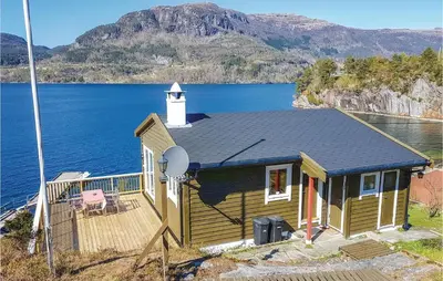 a small house with a lighthouse on a lake at Nice Home In Eikelandsosen With Sauna in Eikelandsosen