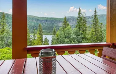 a table on a balcony with a view of a lake at Lovely Home In Eggedal With Wifi in Eggedal