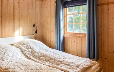 a bedroom with wooden walls and a bed with a window at Lovely Home In Eggedal With Wifi in Eggedal