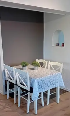 a white table and chairs with a blue table cloth at Apartment by the fjord in Storekra