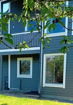 a house with two windows on the side of it at Apartment by the fjord in Storekra