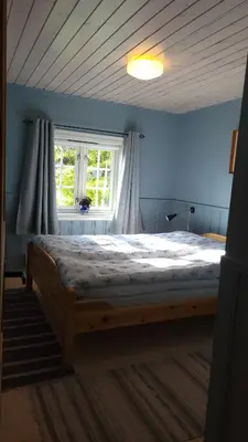 a bedroom with a large wooden bed in front of a window at Hallingstue by Hallstensgaard - Geilo in Geilo
