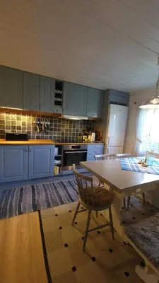 a kitchen with blue cabinets and a table with a chair at Hallingstue by Hallstensgaard - Geilo in Geilo