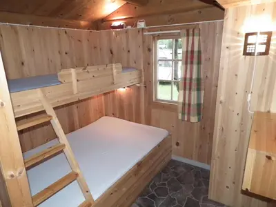 a bunk bed in a cabin with a window at Smegarden Camping in Oppdal