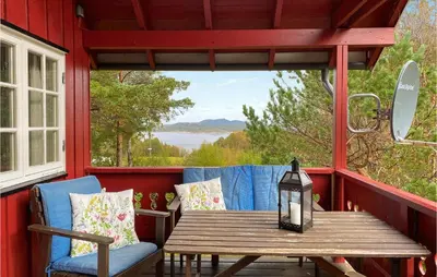 a wooden table and chairs on a porch with a window at Beautiful Home In Tustna With Wifi in Gullstein