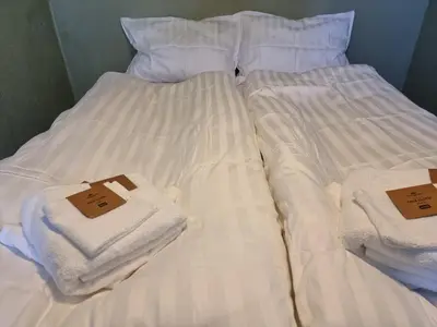 two beds with white towels on top of them at Kjellerleilighet egen inngang. in Stange