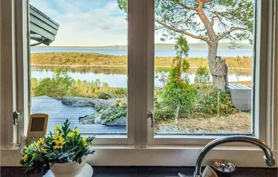 a kitchen window with a view of a lake at Cozy Home In Kjørsvikbugen With Wifi in Taftøya