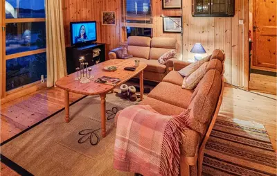a living room with a couch and a table at Cozy Home In Kjørsvikbugen With Wifi in Taftøya