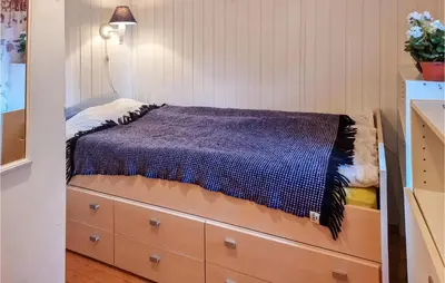a bedroom with a bed and a dresser at Cozy Home In Kjørsvikbugen With Wifi in Taftøya
