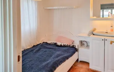 a small bathroom with a bed and a sink at Cozy Home In Kjørsvikbugen With Wifi in Taftøya