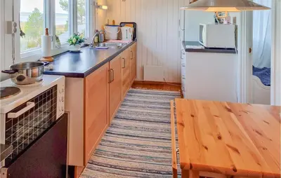 a kitchen with a sink and a stove top oven at Cozy Home In Kjørsvikbugen With Wifi in Taftøya