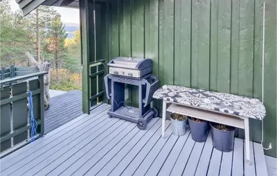 a grill and bench on a porch of a house at Cozy Home In Kjørsvikbugen With Wifi in Taftøya