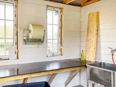 a kitchen with a counter and a sink and windows at 6 person holiday home in AVERØY-By Traum in Stein