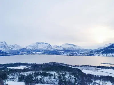 an aerial view of a lake with snow covered mountains at 6 person holiday home in AVERØY-By Traum in Stein