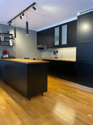 a kitchen with black cabinets and a wooden floor at Leilighet i Oppdal - 4 soverom, 2 stuer og 2 bad in Oppdal
