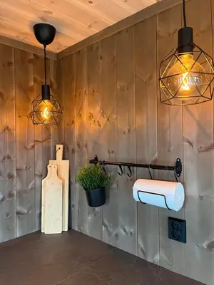 a bathroom with two lights on a wooden wall at Polaren by Norgesbooking - cabin with amazing view in Notodden