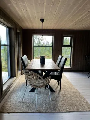 a dining room with a wooden table and chairs at Polaren by Norgesbooking - cabin with amazing view in Notodden